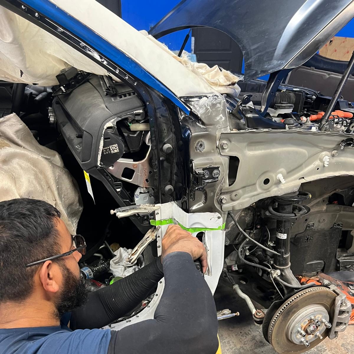 Technician fitting a structural panel during unibody repair